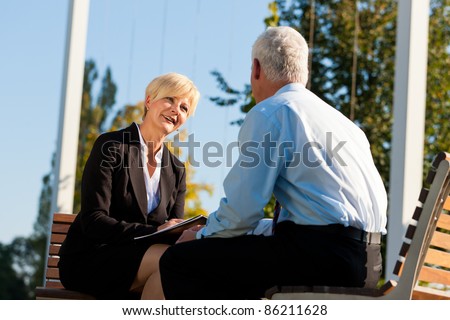 Business coaching outdoors - a man and a woman have a coaching discussion