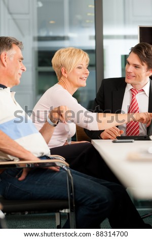 Mature couple with young financial consultant - they are planning their retirement