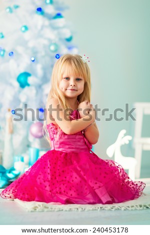 little girl dresses up Christmas tree