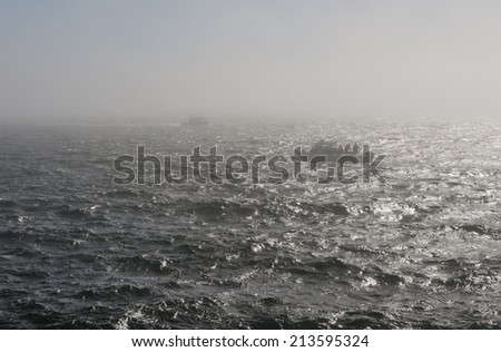 Boats in ocean in foggy day