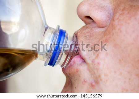man drinks juice through a throat