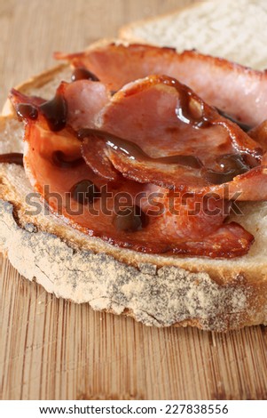 Freshly made bacon sandwich with brown sauce selective focus on the bacon
