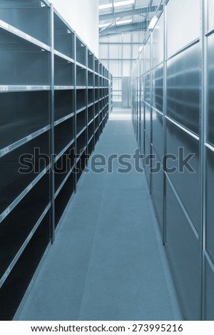 Newly installed empty warehouse storage shelves and racks in a generic warehouse rendered in blue tint