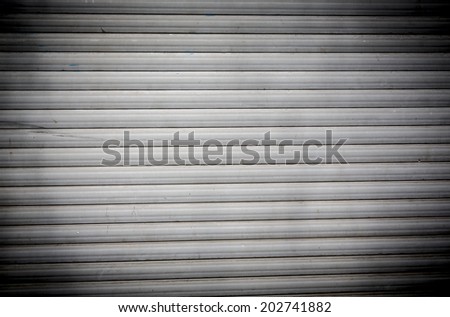 dirty old roller shutter for backgrounds, with strong vignette.