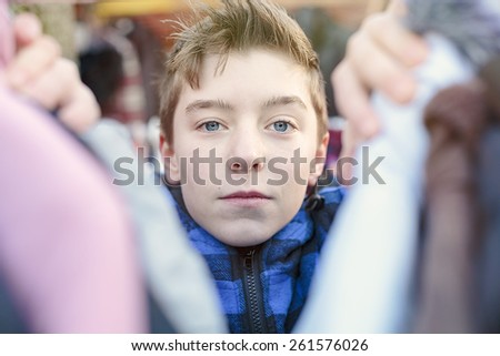 portrait of a teenage boy who is looking after clothes on a flea market