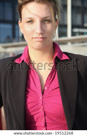 Young businesswoman posing and looking at you.