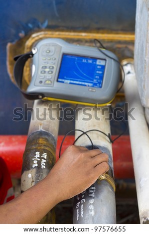 a hand of worker checking quality of weld using industrial ultrasonic device