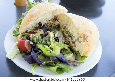 Tuna Salad Sandwich with Ciabatta Bread and Leafy Mixed Green Salad with Tomatoes Closeup