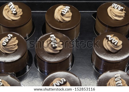 Chocolate Mousse Cake Decorated with Whipped Cream and Dark Chocolate at Bakery Shop Closeup