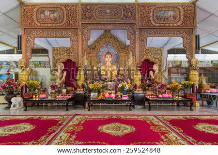 PENANG, MALAYSIA, MARCH 10, 2015: Dhammikarama Burmese Buddhist Temple Altar with Buddha and two Monks Statues. This temple is a popular tourist attraction for both locals and tourists.