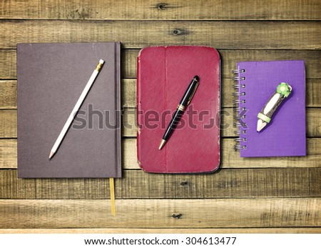 Set old notebook and pencil on wood background.