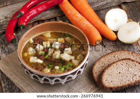 Pea soup with carrot and bacon in pot