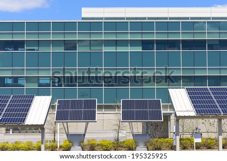 Ground level solar panel arrays in front of modern office building