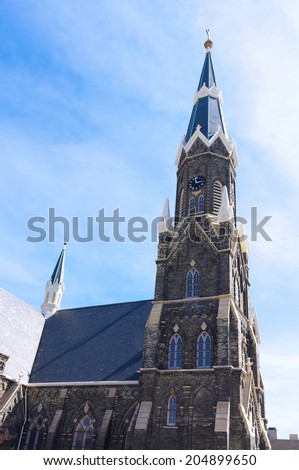 Spire atop clock tower of historic church constructed in gothic revival architecture style in Milwaukee Wisconsin