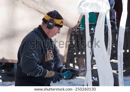 SAINT PAUL, MN/USA  JANUARY 25, 2015: Ice sculptor shapes artwork during competition at St. Paul Winter Carnival. It is the nation\'s oldest winter festival attracting over 250,000 visitors a year.