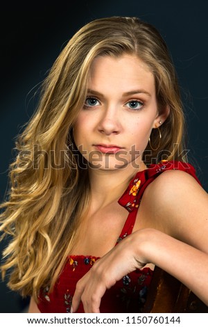 Blond Teenager Girl Posing For Portrait With Dark Background 1150760144 Blond Teenager Girl Posing For Portrait With Dark Background 1150760144