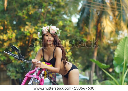 Young sexy Asian woman in black lingerie on pink motorcycle.