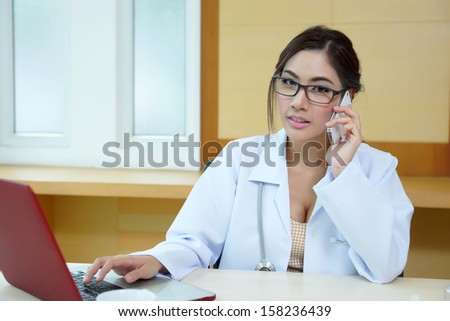 Young doctor woman speaking by phone mobile in her office.