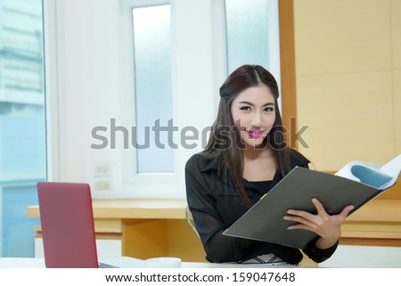Pretty business lady working at desk, Model is Asian woman.