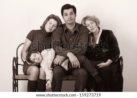 Family - Grandmother, mother, father and child sitting on the bench and sleeping Black and white portrait