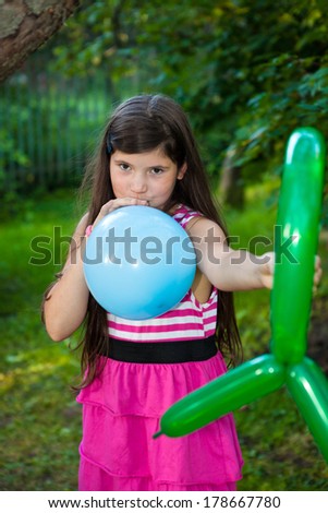 beautiful preteen girl with dark long hair playing with balloons