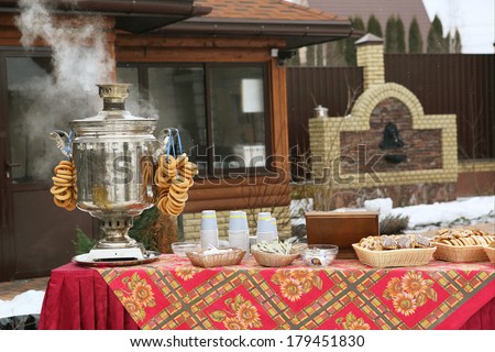 samovar and other russian snack food on the beautiful designed table on the winter mansion house background