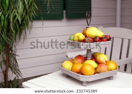 beautiful composition of fruit plate and outdoor table on the white mansion background