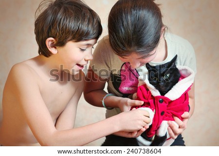 naughty brother and sister dress cat in santa costume