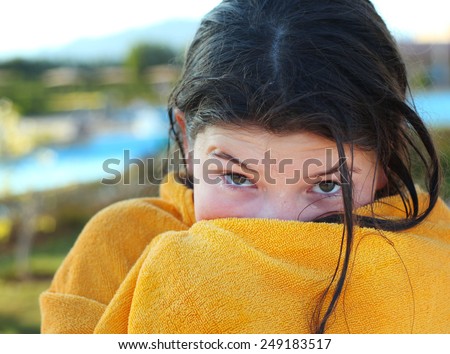 beautiful preteen girl with dark hair in yellow towel after swimming in egyptian water park pool