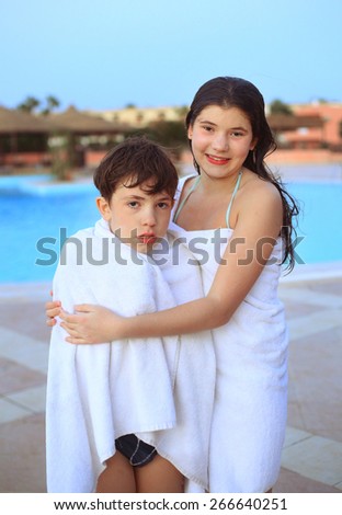 beautiful siblings brother and sister in  towel after swimming in egyptian water park pool