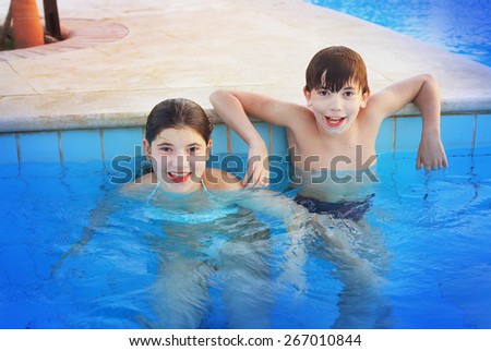 siglings boy and girl play in open air swimming pool at the egyptian sea resort hotel