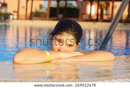 preteen beautiful girl  in open air swimming pool at the egyptian sea resort hotel