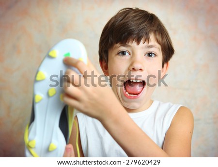 teen handsome boy with brand new yellow football boots close up photo