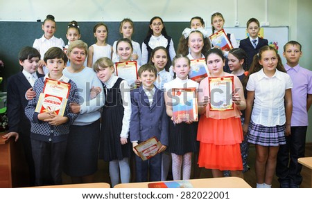 MOSCOW, MAY 26, 2015: Graduation in the primary school in Moscow, May 26. Graduating pupils with their teacher  gets diploma and then go to the middle school.