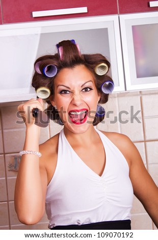crazy housewife with a knife in his hand and curlers in her hair