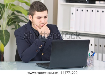 young businessman looking at the laptop and thinking about future jobs