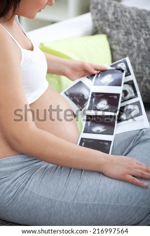 Pregnant woman looking  a photo of her Ultrasound