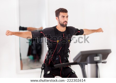 fit man exercise on  electro muscular stimulation machine