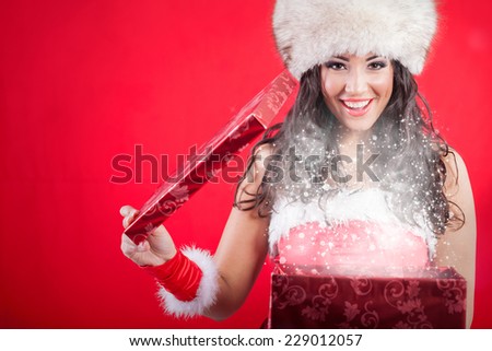 Santa woman in hat opening box with present,red background