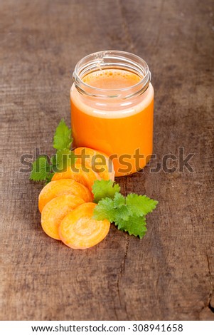 Freshly squeezed juice of carrots on a wooden background,close up