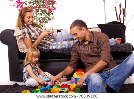 Father playing with daughters while mom relaxes with coffee