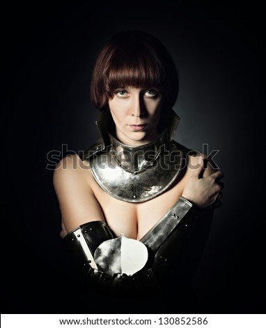 Portrait of sexy medieval female knight in armour over black background