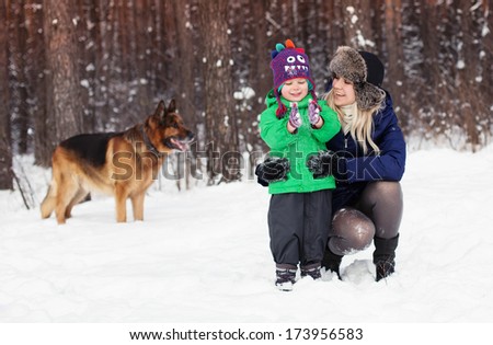 Laughing family and german shepherd dog in winter park
