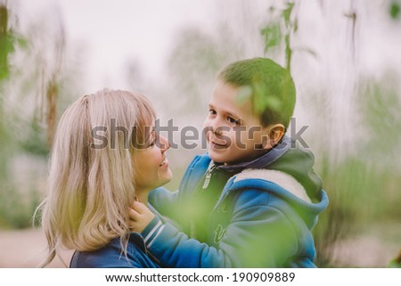 Son is kissing his mother outdoor in the park