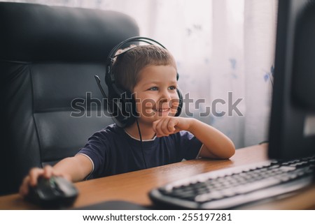 little boy with headset using computer, early education and learning