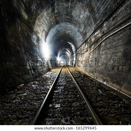 Light at the end of railroad tunnel. Natural lighting.
