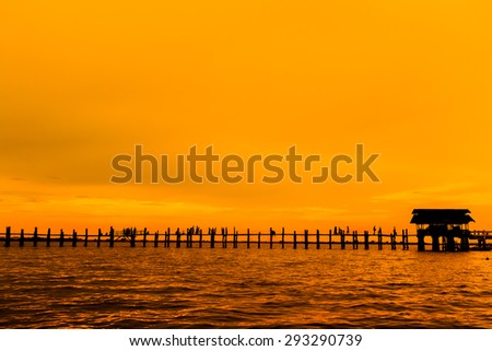 Silhouetted person on U Bein Bridge at sunset, Amarapura, Mandalay region, Myanmar