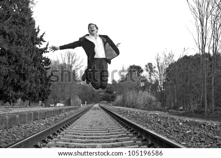 Young man wit suit jumping in rail way