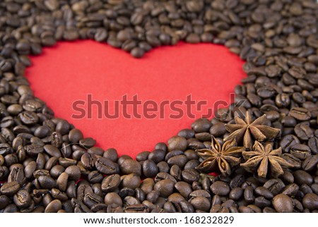 Red paper heart  and star anise on background of coffee beans. Textures of roasted coffee bean with red heart for background. Valentine\'s day, wedding, love