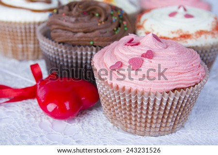 Close up set of colorful cupcakes with hearts for Valentine\'s Day, valentines on wooden background, brown table. Chocolate Cupcake, strawberry, pink, bright, white, vanilla.